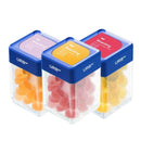 Three clear square containers with blue lids labeled "Urb" contain differently colored gummy supplements: orange, pink, and yellow. Each lid is also labeled with the word "Boarding." These are Urb Boarding Skybites Delta 9 Gummies, perfect for those seeking Delta 9 THC or CBD gummies.