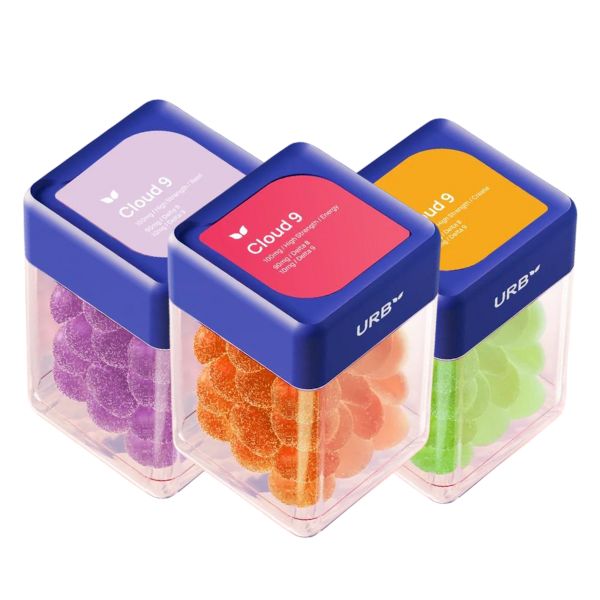 Three small cuboid containers with blue lids, each containing colorful gummy candies meticulously arranged in rows. The labels read "Urb Cloud 9" in different colors: purple, red, and yellow. These Urb Cloud 9 Skybites Gummies are infused with Delta-8 for an enhanced touch of relaxation.