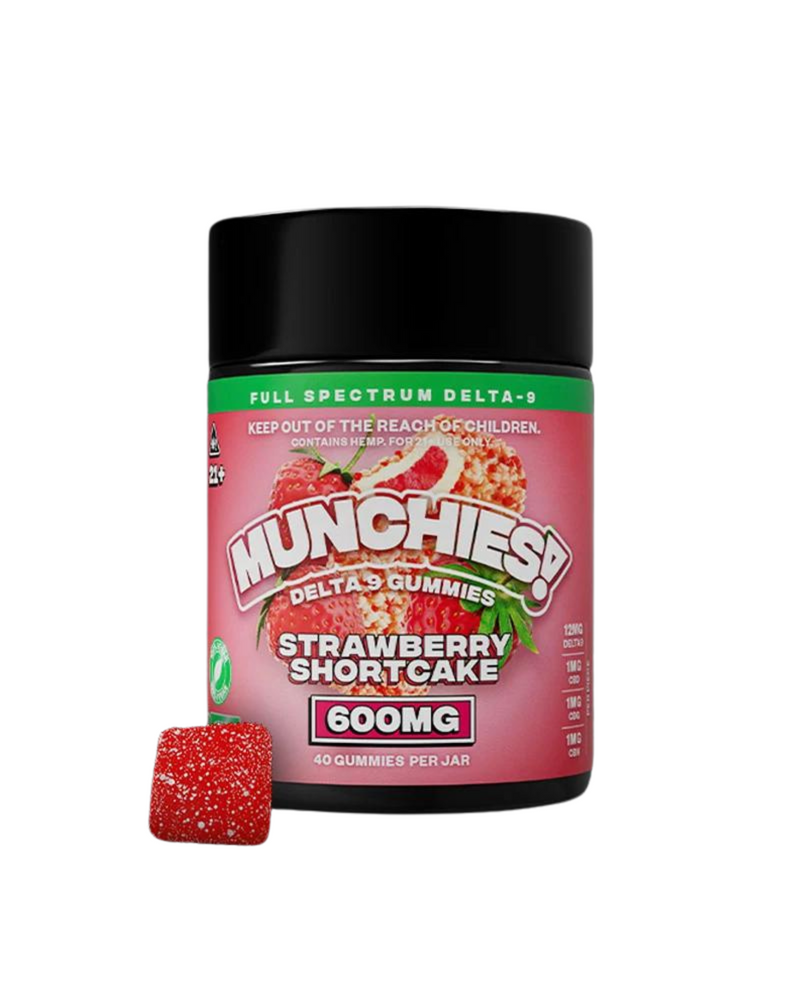 A black jar labeled "Delta Munchies Delta 9 Gummies Strawberry Shortcake 600mg." Contains 40 Full Spectrum Gummies. One gummy is outside the jar. Text advises to keep out of reach of children.