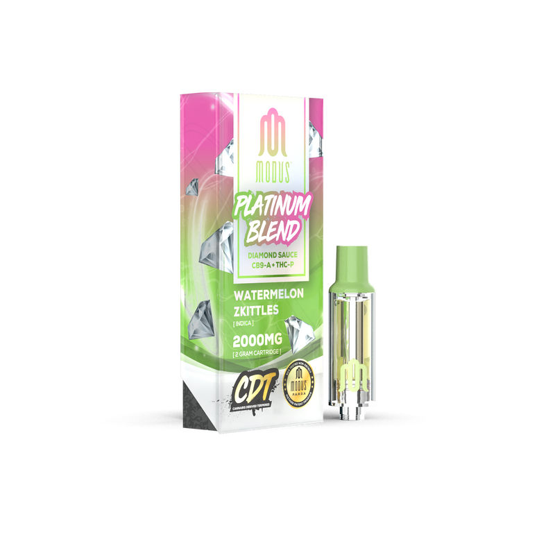 A rectangular box labeled “Modus Platinum Blend Cartridge | 2g” by Modus, flavored Watermelon Zkittles, 2000mg, with a small, clear cartridge beside it. The box is pink, green, and white with diamond and watermelon imagery. Featuring the premium Modus Platinum Blend Vape Carts, this product promises an exceptional experience.