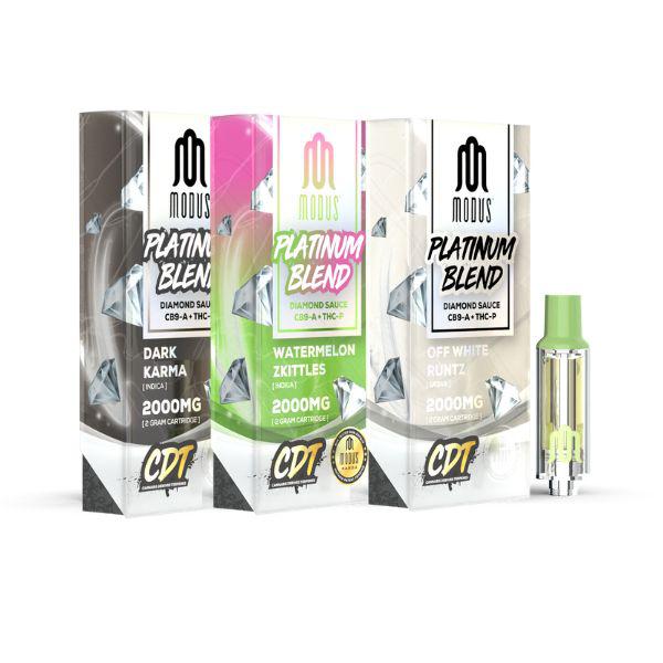 Three packaged vaping cartridges labeled "Modus Platinum Blend Cartridge | 2g" in Dark Karma, Watermelon Zkittles, and Off White Runtz variants. Each package displays 2000mg, with a cartridge beside them. Experience the luxury of Modus Platinum Blend Vape Carts infused with the essence of premium Diamond Sauce.
