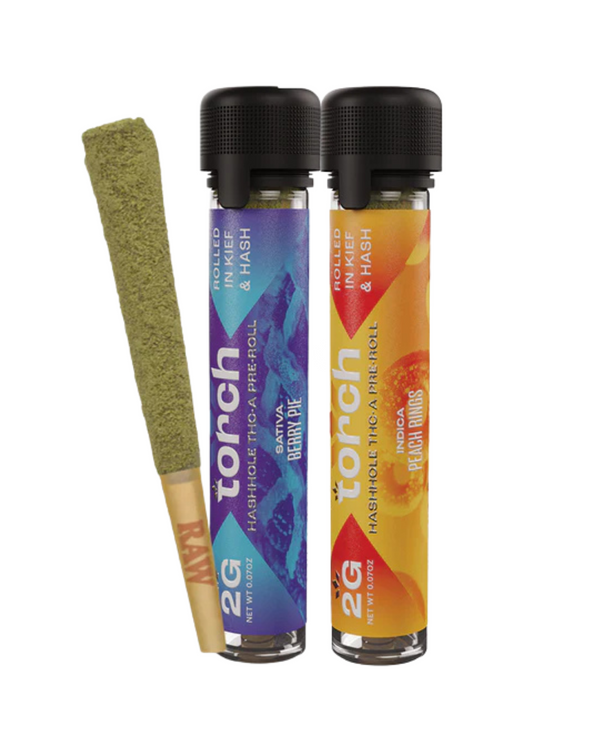 Two cylindrical containers labeled "Torch Hashhole THCA Pre-Roll" for cannabis pre-rolls infused with hash are offered in Berry Gelato and Peach Rings flavors, each weighing 2 grams. Beside them is a singular cannabis pre-roll showcasing premium THC-A indoor flower for an enhanced experience.