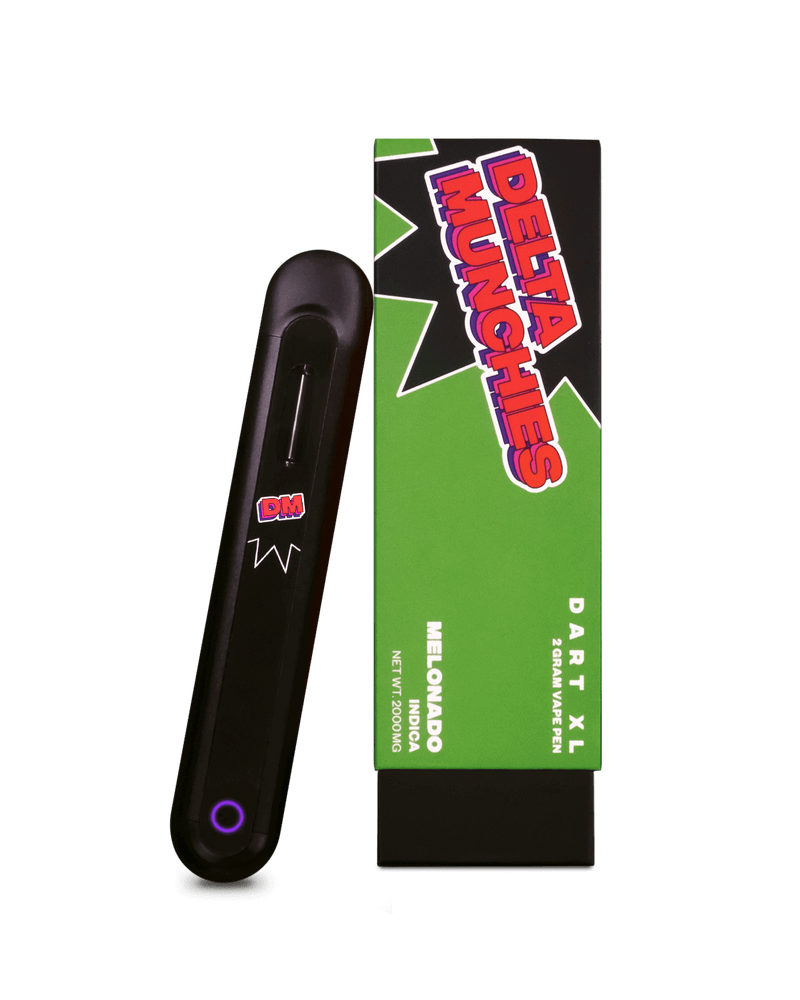 A black vaping device labeled "DM" is placed next to a green and black box with the label "Delta Munchies Dart XL." This Delta Munchies Dart XL Delta 8 Disposable Vape offers 2.5 grams of Premium Quality American Hemp, weighing 2500mg. Enjoy the automatic draw feature for a seamless experience.