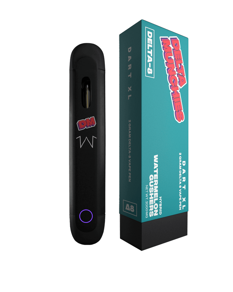 A black Delta Munchies Dart XL vape pen is shown next to its teal and pink packaging, labeled "Watermelon Gushers." This Delta 8 disposable vape from the brand Delta Munchies features automatic draw technology and is crafted from premium quality American hemp.